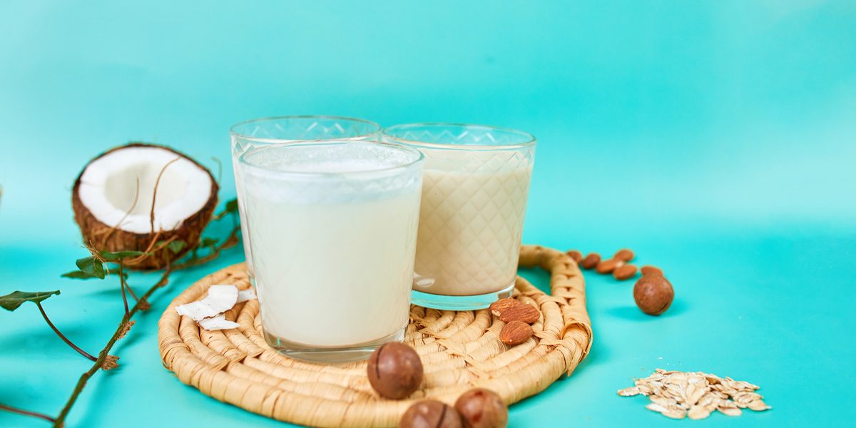 2 dairy free coconut milk in cups with coconut fruit