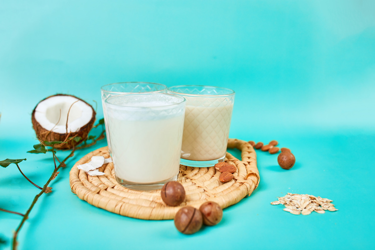 2 dairy free coconut milk in cups with coconut fruit